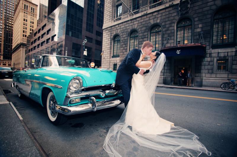 Happy couple with 1956 plymouth convertible Wedding car